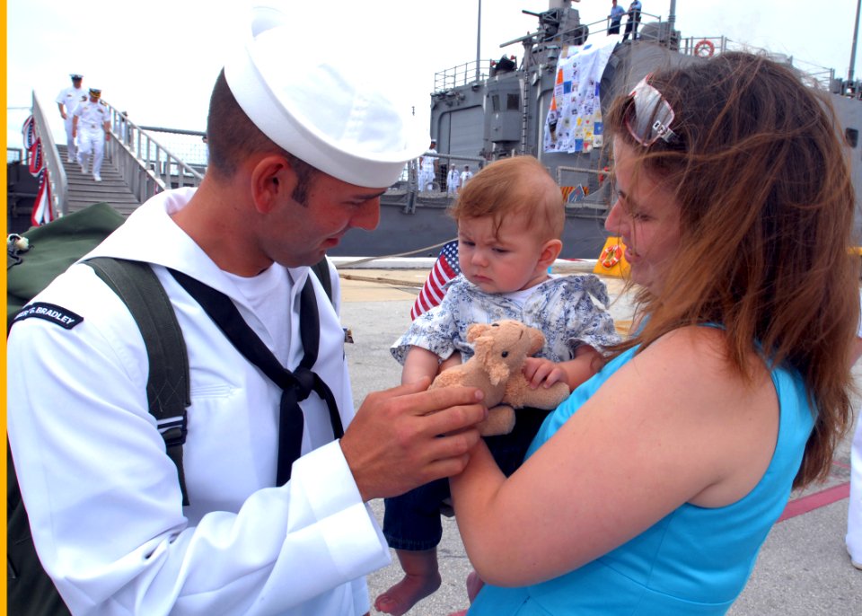 US Navy 090523-N-0486G-012 Boatswains Mate 3rd class Jeremy Allan hands a teddy bear to his 5-month old son as they meet for the first time. Allan returned from a six-month deployment aboard the guided-missile frigate USS Rober
