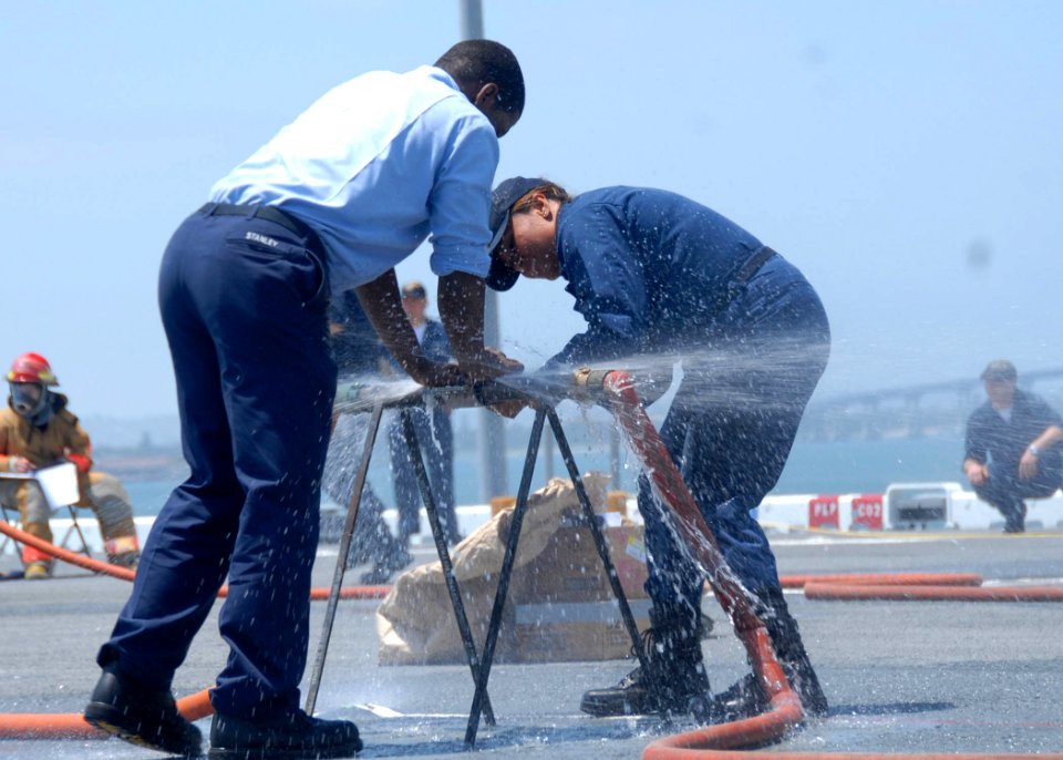 US Navy 090522-N-0515W-053 Mass Communication Specialist Seaman Marcus Stanley and Air Traffic Controller 3rd Class Jolyn SanNicolas attempt to repair a cracked pipe during a Damage Control Olympics