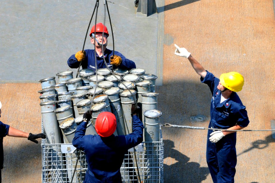 US Navy 090520-N-7478G-328 Fire Controlman 2nd Class Jason Schannot holds the wire steady as Gunner's Mate James Wanless acts as crane rigger and directs the offload of ammunition