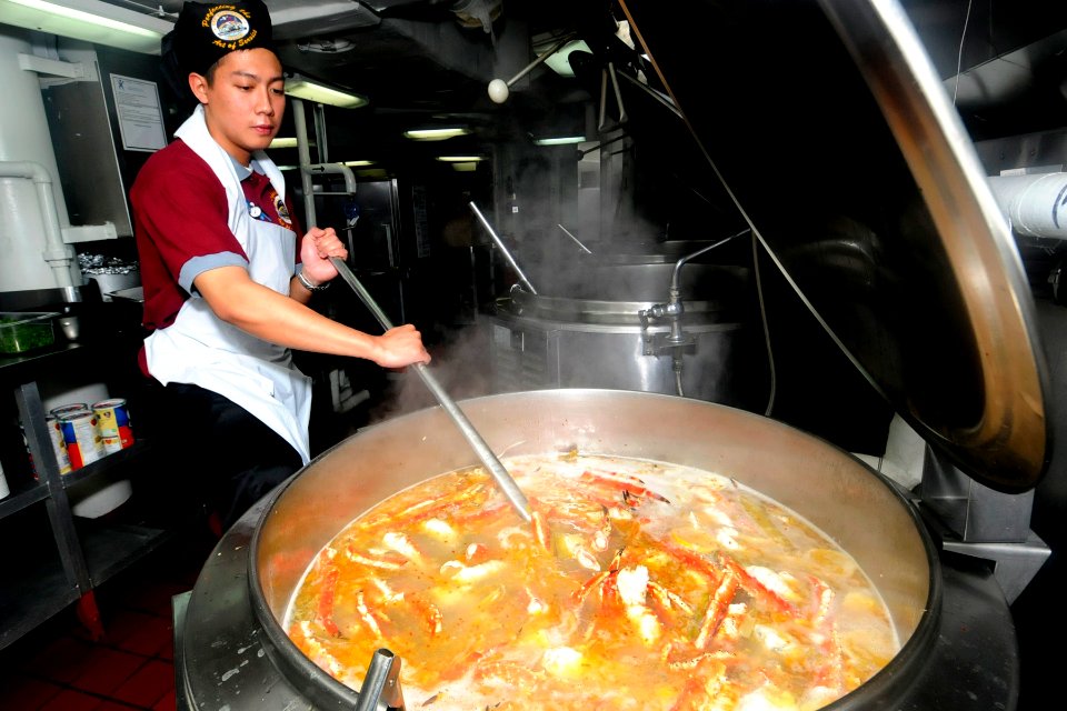 US Navy 090521-N-7478G-059 Culinary Specialist Seaman Manuelito Belocura stirs a pot of crab legs for dinner on the last night the amphibious command ship USS Blue Ridge (LCC 19)