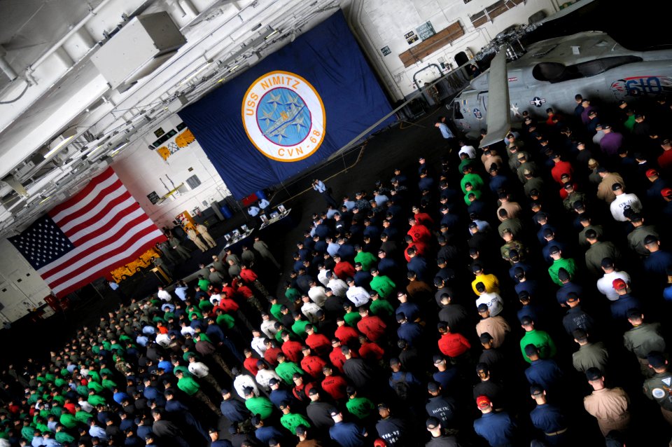 US Navy 090523-N-1786N-028 Sailors aboard the aircraft carrier USS Nimitz (CVN 68) bow their heads during a prayer while a memorial service is conducted in the hangar bay