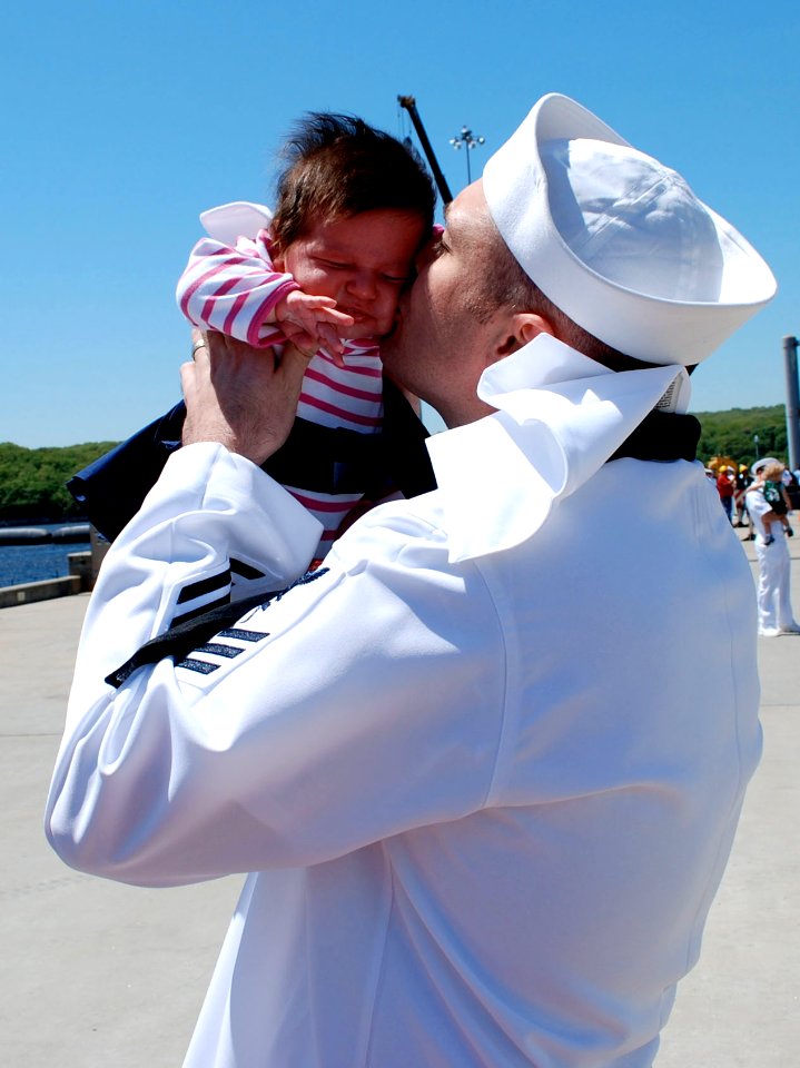 US Navy 090521-N-8750E-139 Hospital Corpsman 1st Class Chris Yaras kisses his daughter for the first time during the return of the Los Angeles class fast-attack submarine USS Hartford (SSN 768) to Naval Submarine Base New Londo