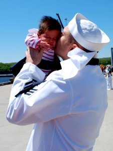 US Navy 090521-N-8750E-139 Hospital Corpsman 1st Class Chris Yaras kisses his daughter for the first time during the return of the Los Angeles class fast-attack submarine USS Hartford (SSN 768) to Naval Submarine Base New Londo photo