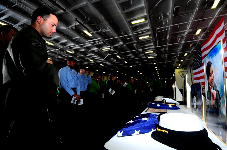 US Navy 090523-N-3946H-089 Lt. j.g. Kasey Scheel, assigned to Helicopter Anti-Submarine Squadron (HS) 6, looks at pictures and mementos during a memorial service in the hangar bay of the aircraft carrier USS Nimitz (CVN 68)