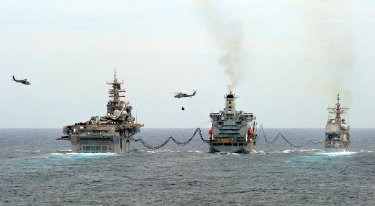 US Navy 090523-N-5345W-062 The amphibious assault ship USS Bataan (LHD 5), left, and the guided missile cruiser USS Anzio (CG 68), right, conduct a replenishment at sea
