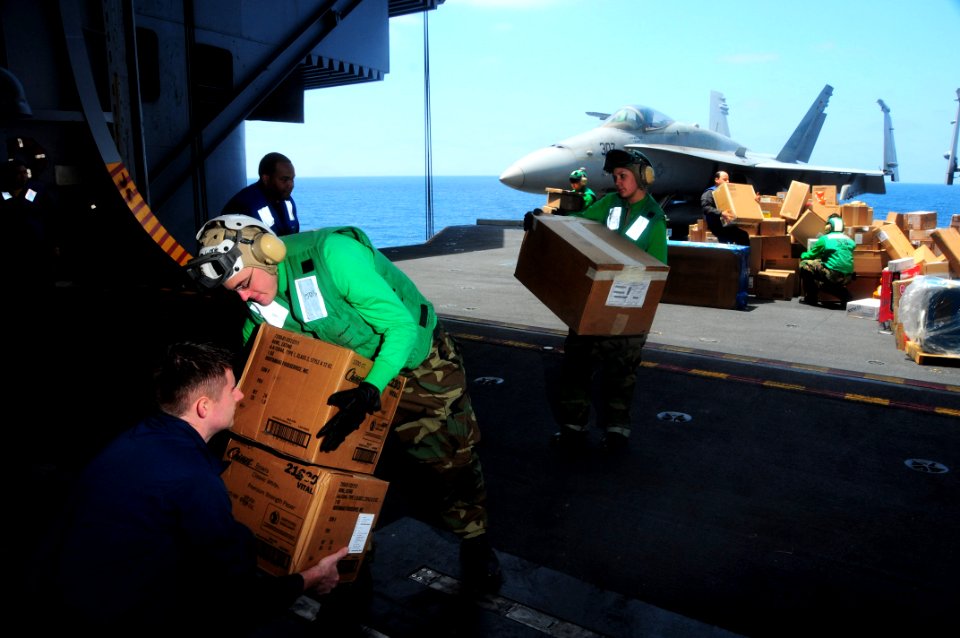 US Navy 090522-N-3946H-050 Seaman John Algood hands off boxes of supplies to Seaman Paul Despain during a carrier onboard delivery aboard the aircraft carrier USS Nimitz (CVN 68)