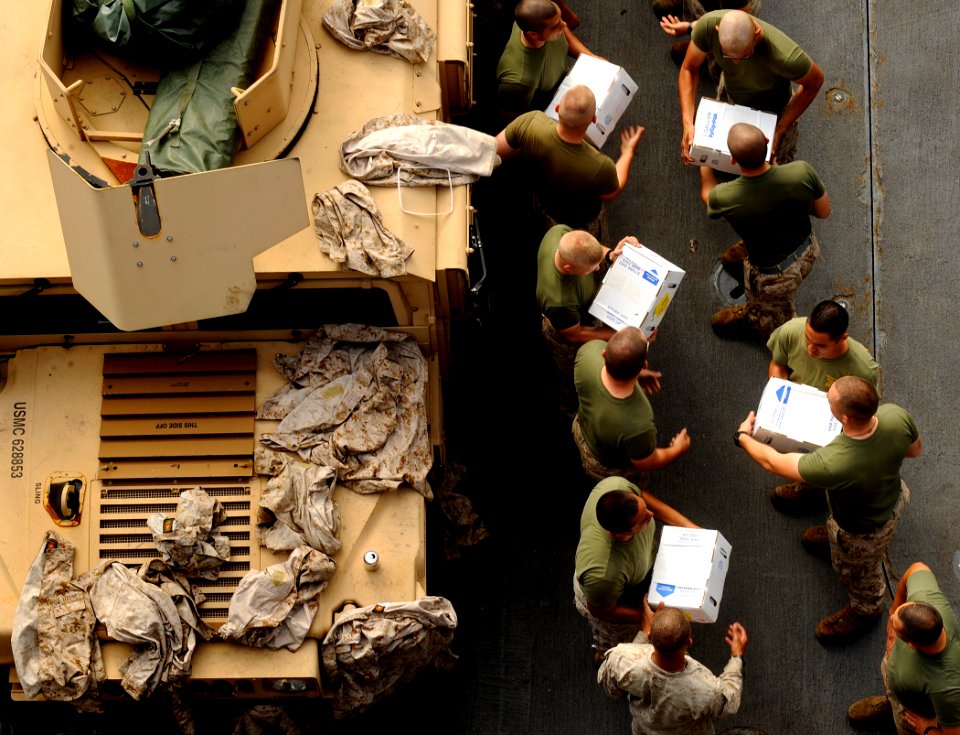 US Navy 090523-N-5345W-230 Marines from the 22nd Marine Expeditionary Unit (22 MEU) form an assembly line to help transfer stores from the flight deck after they were delivered to the amphibious dock landing ship USS Fort McHen