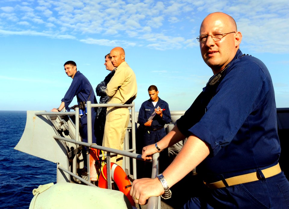 US Navy 090523-N-5345W-324 Lt. Cmdr. Brian Goldschmidt, right, executive officer of the amphibious dock landing ship USS Fort McHenry (LSD 43), watches from outside the pilothouse