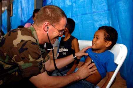 US Navy 090526-F-1333S-037 A service member embarked aboard the Military Sealift Command hospital ship USNS Comfort (T-AH 20) provides medical treatment to a patient at the Puerto Pilon Gym photo