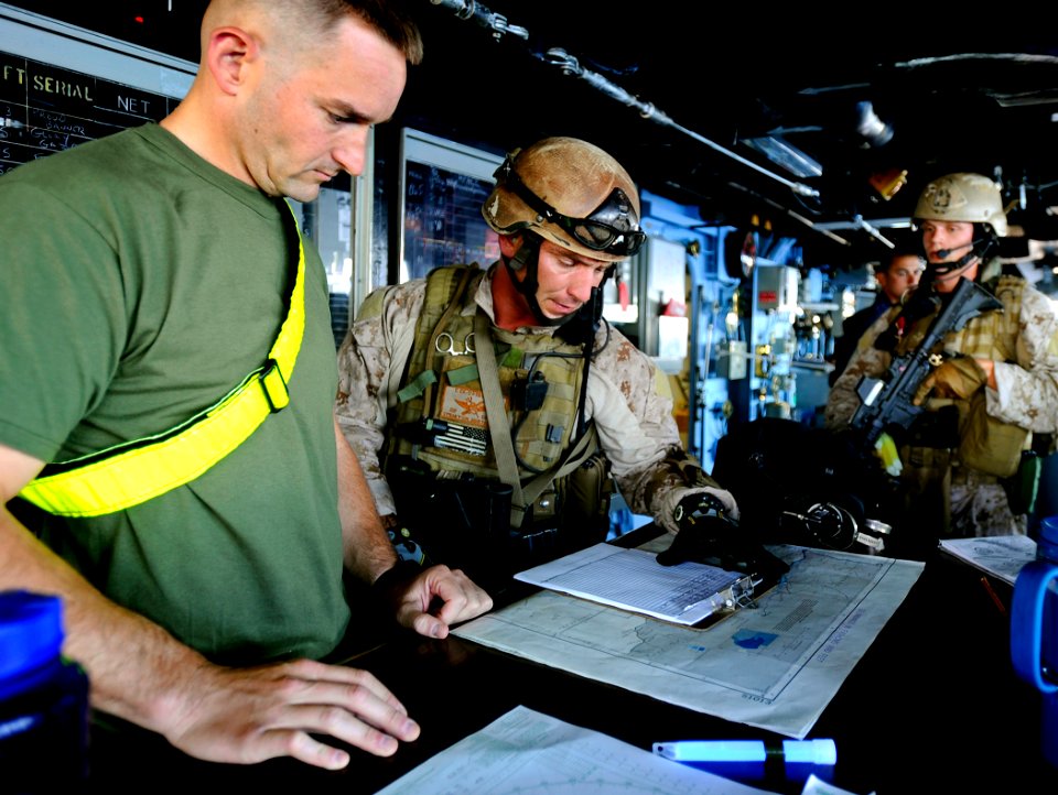 US Navy 090526-N-5345W-125 Marines assigned to the visit, board, search and seizure team review the ship's manifest and charts in the bridge with simulated crew members during a non-compliant merchant vessel drill
