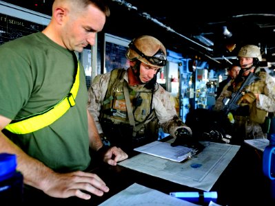 US Navy 090526-N-5345W-125 Marines assigned to the visit, board, search and seizure team review the ship's manifest and charts in the bridge with simulated crew members during a non-compliant merchant vessel drill