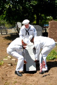 US Navy 090522-N-4936C-073 Sailors assigned to the guided-missile cruiser USS Vella Gulf (CG 72) place a new headstone for a World War I veteran at Lake Cemetery in Staten Island photo