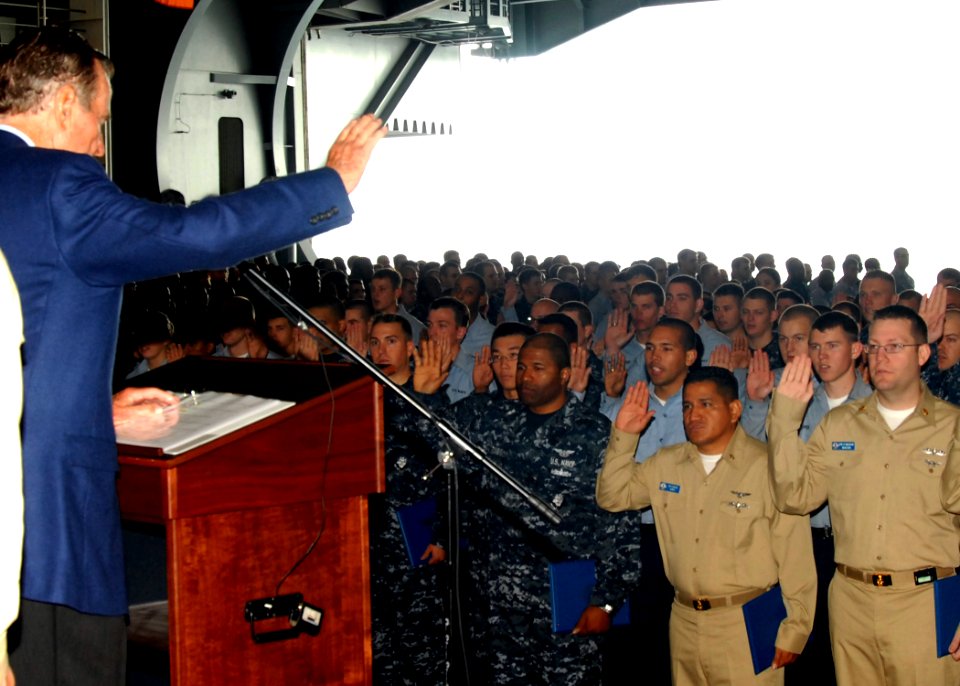 US Navy 090527-N-6125G-009 Former U.S. President George H.W. Bush reads the Oath of Enlistment during a mass re-enlistment and frocking ceremony in the hangar bay the aircraft carrier USS George H.W. Bush (CVN 77)