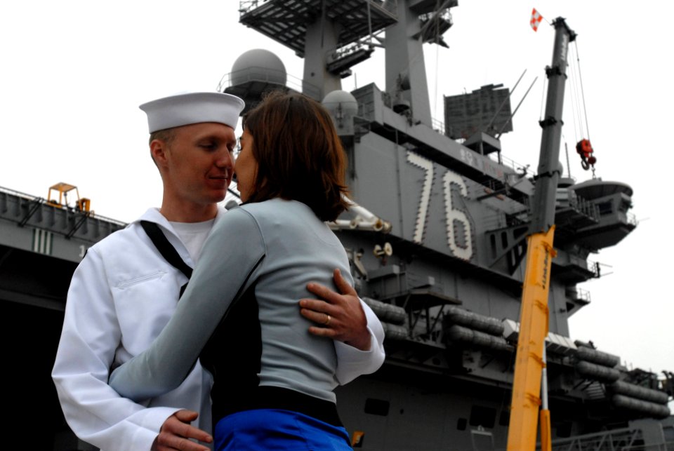 US Navy 090528-N-2344B-078 Air Traffic Controller 3rd Class Andrew Lundeen kisses wife good-bye in front of the aircraft carrier USS Ronald Reagan (CVN 76)