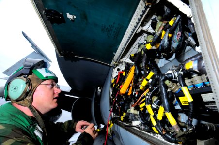 US Navy 090528-N-3946H-093 Aviation Electronics Technician 3rd Class William Cooley uses a multimeter to perform maintenance on cannon plugs on an F-A-18C Hornet aboard the aircraft carrier USS Nimitz (CVN 68)