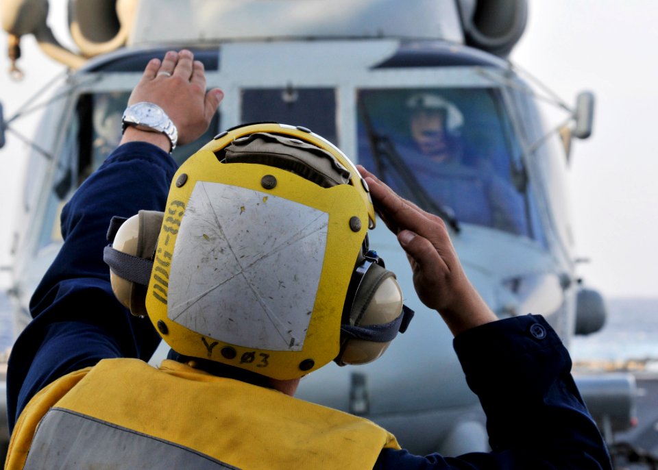 US Navy 090529-N-2638R-003 Boatswain's Mate 2nd Class Travis Page, from Moore Haven, Fla., a landing signalman enlisted (LSE) aboard the Arleigh Burke-class guided-missile destroyer USS Mustin (DDG 89), signals to the pilot of