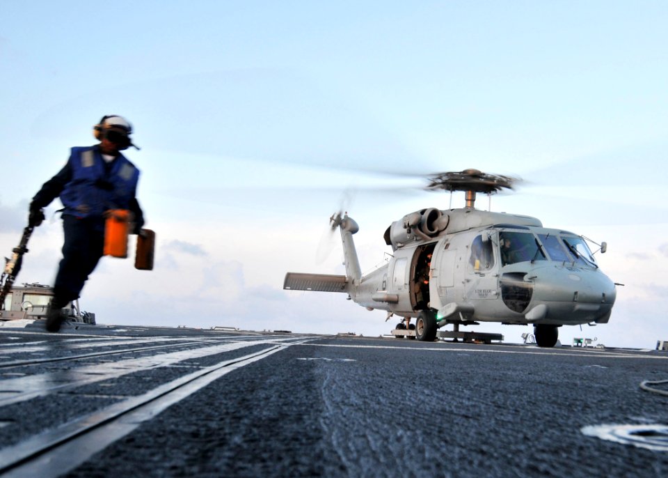 US Navy 090529-N-2638R-005 Boatswain's Mate Seaman Tiffany Walker, from New York, runs to a safe area after pulling the chocks and chains from a SH-60F Seahawk helicopter