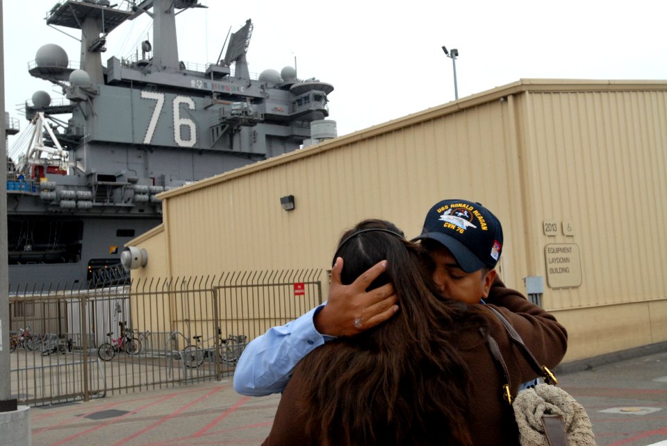 US Navy 090528-N-2344B-034 Personnel Specialist 1st Class Ricardo Rivera gives a goodbye hug to his wife before boarding the aircraft carrier USS Ronald Reagan (CVN 76)