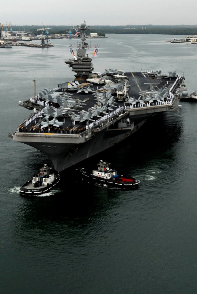 US Navy 090528-N-7780S-643 Sailors manning the rails on the flight deck of the aircraft carrier USS John C. Stennis (CVN 74) stand at parade rest before rendering hand salutes as the ship passes the USS Arizona Memorial