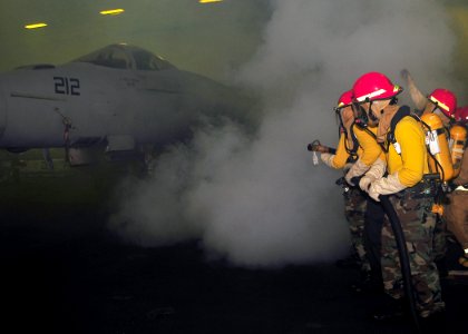 US Navy 090528-N-6233C-010 ailors assigned to the Air department, V3 division aboard the aircraft carrier USS George Washington (CVN 73) fight a simulated hangar bay aircraft fire during a general quarters drill