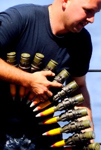 US Navy 090529-N-5345W-126 Gunner's Mate 2nd Class Michael Miller downloads an ammo belt from an MK 38 25mm gun