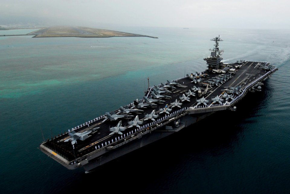 US Navy 090528-N-7780S-155 Sailors manning the rails on the flight deck of the aircraft carrier USS John C. Stennis (CVN 74) stand at parade rest before rendering hand salutes as the ship passes the USS Arizona Memorial