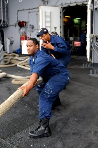 US Navy 090528-N-7032B-107 Boatswain's Mate Seaman Jermia Millsap, from Chicago, and Boatswain's Mate Seaman Maurice Enis, from Philadelphia, heave in line 12 on the fantail of the aircraft carrier USS Ronald Reagan (CVN 76)