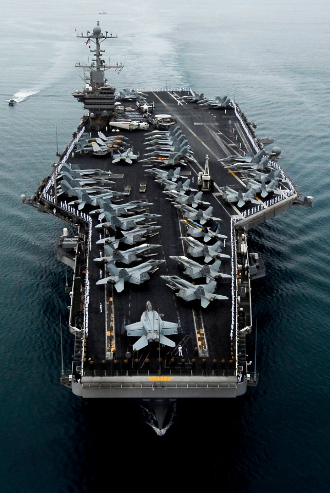 US Navy 090528-N-7780S-161 Sailors manning the rails on the flight deck of the aircraft carrier USS John C. Stennis (CVN 74) stand at parade rest before rendering hand salutes as the ship passes the USS Arizona Memorial