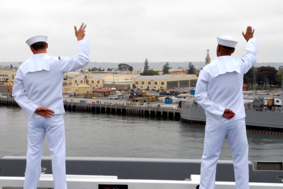US Navy 090528-N-5586R-203 Sailors aboard to the aircraft carrier USS Ronald Reagan (CVN 76) manning the rails wave to family members as they leave their home port of San Diego