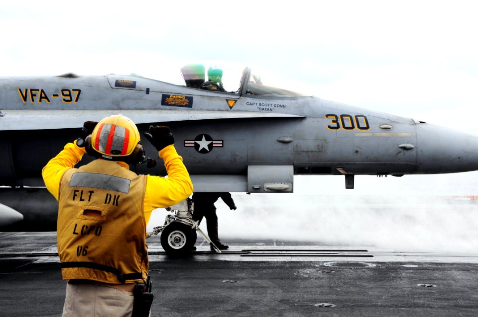 US Navy 090530-N-3946H-082 A Chief Aviation Boatswain's Mate guides an F-A-18C Hornet