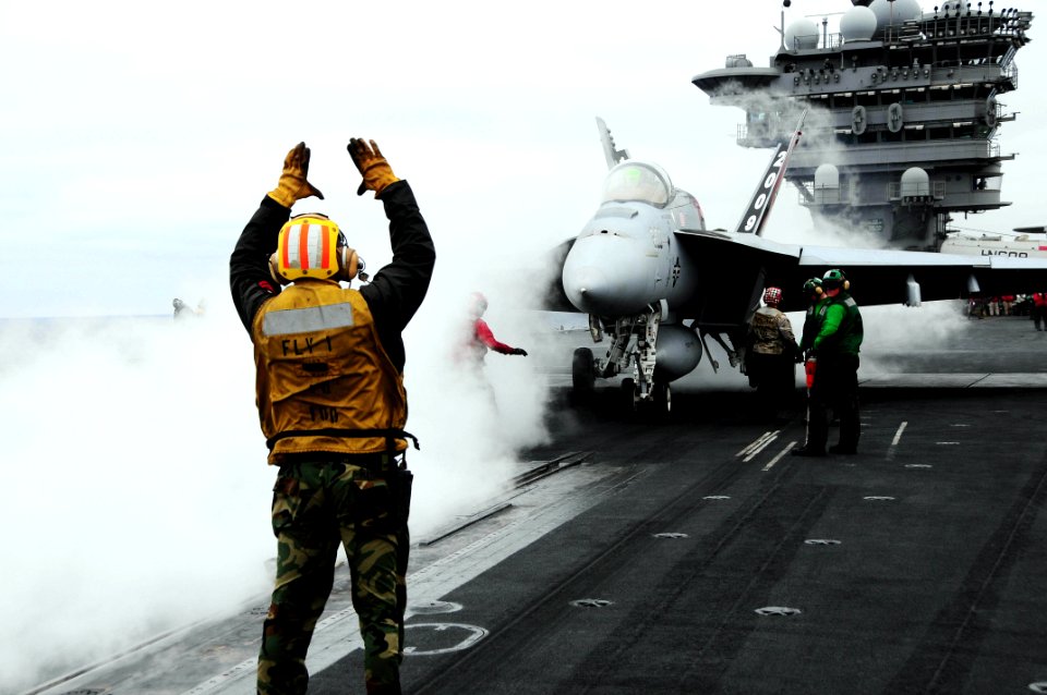 US Navy 090601-N-3946H-045 An aircraft director guides an F-A-18E Super Hornet, assigned to the