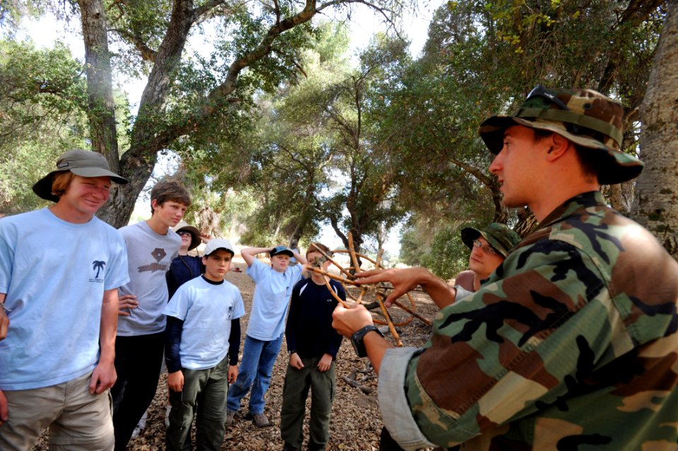 US Navy 090530-N-2959L-047 Fire Controlman 2nd Class Daniel Illanchi shows members of Boy Scout Troop 806 of Coronado, Calif. a trap used to catch food during wilderness survival training