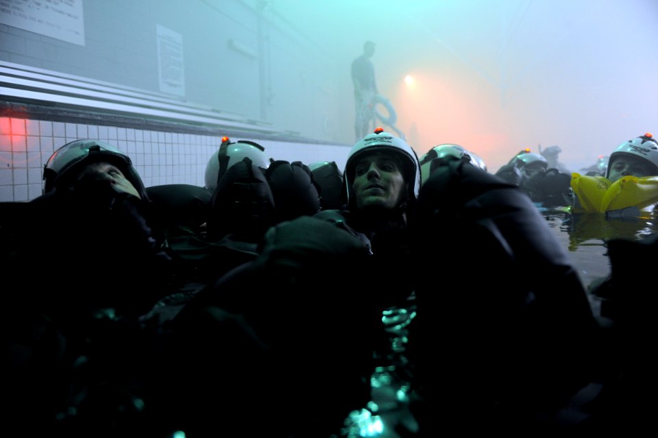 US Navy 090604-N-0413R-080 Students huddle to account for their classmates as they complete the final dunk and lap swim exercise during the simulated storm at the Aviation Survival Training Center in Jacksonville, Fla