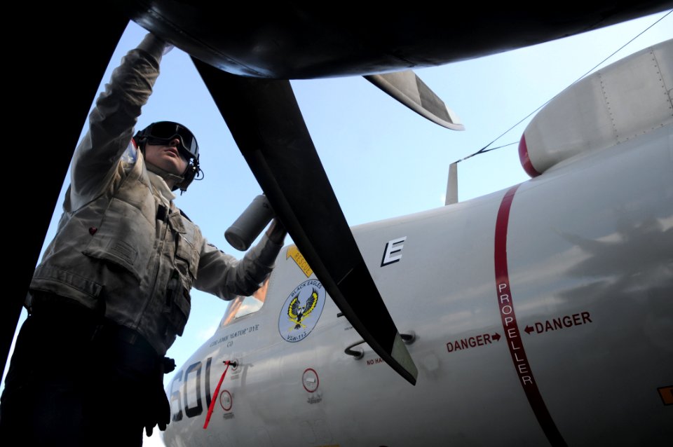 US Navy 090603-N-3610L-237 Aviation Machinist's Mate 3rd Class Galen Hannah applies erosion film on the propeller blade of an E-2C Hawkeye
