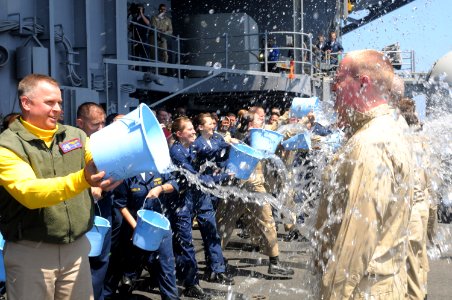 US Navy 090601-N-7032B-052 Newly sworn in Lt. j.g. Nick Casaletto, from Evansville, Ind., is soaked by Capt. K.J. Norton, commanding officer of the aircraft carrier USS Ronald Reagan (CVN 76) during the photo