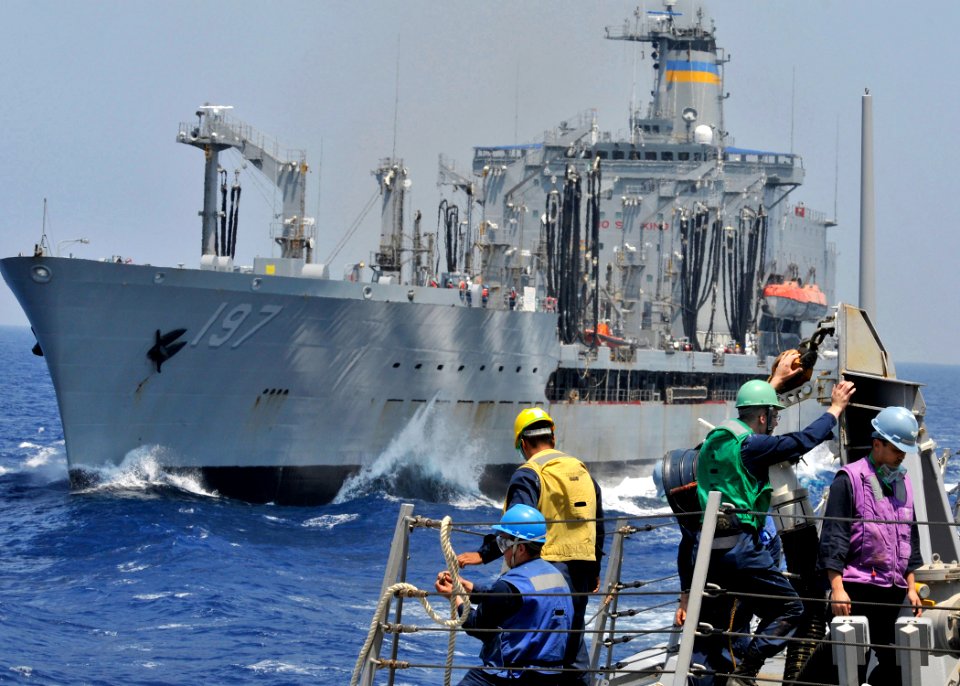 US Navy 090602-N-2638R-004 Sailors aboard the guided-missile destroyer USS Mustin (DDG 89) secure a refueling station as the ship pulls away from the Military Sealift Command fleet replenishment oiler USNS Pecos (T-AO 197)
