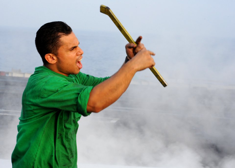 US Navy 090606-N-9988F-079 Aviation Boatswain's Mate (Equipment) 1st Class Roy Diaz signals flight deck personnel