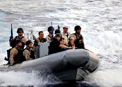 US Navy 090531-N-2638R-006 Sailors assigned to the visit, board, search and seizure (VBSS) team of the guided-missile destroyer USS Mustin (DDG 89) approach Mustin after completing a VBSS drill photo