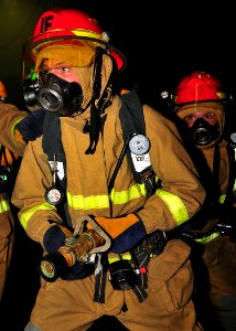 US Navy 090603-N-6233C-049 Aviation Electronics Technician Airman Travis Bones fights a simulated fire in the hangar bay of the aircraft carrier USS George Washington (CVN 73)