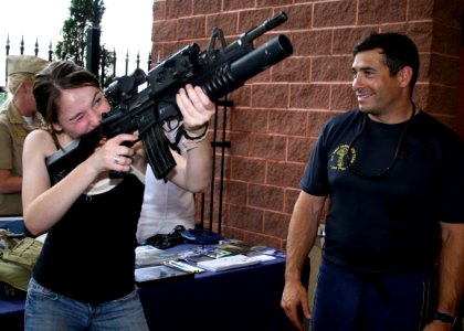 US Navy 090602-N-5366K-052 Special Warfare Operator 1st Class (SEAL) Robert Darakjy, assigned to the U.S. Navy Parachute Team the Leap Frogs, shows a display M-4 assault rifle to a Washington Wild Things baseball fan photo