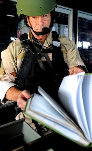 US Navy 090609-N-5345W-155 LT John Fairweather, assigned to Naval Beach Group 2, checks over the ship's bridge logbook while serving as a Visit, Board, Search and Seizure (VBSS) team leader during a VBSS drill photo