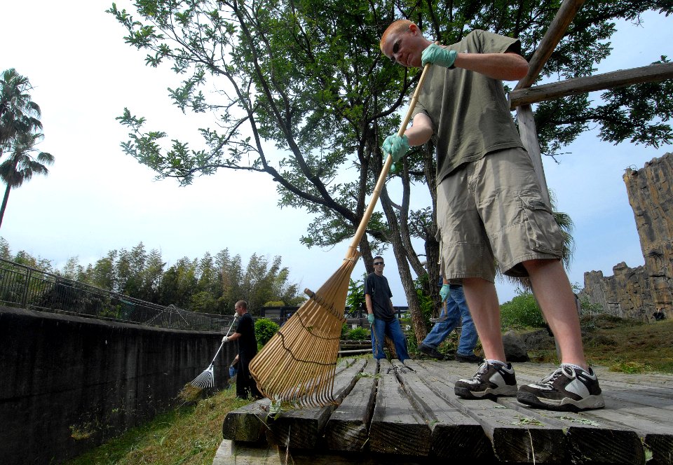 US Navy 090604-N-0807W-192 Seaman Johnson J. Corey, from Minnetonka, Minn. assigned to Assault Craft Unit (ACU) 1, clears weeds and debris from inside the lions den at Ishidake Zoo during a community service project