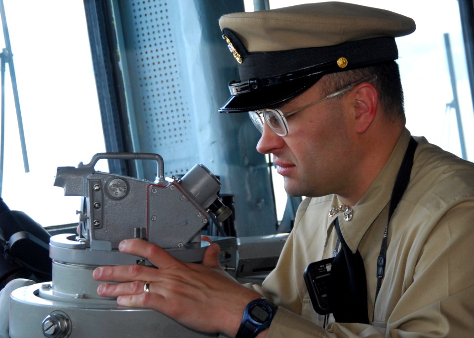 US Navy 090603-N-3165S-002 Senior Chief Quartermaster David Tokarski looks through a sexton on the bridge of the multi-purpose amphibious assault ship USS Bataan (LHD 5) during the ship's Battle of Midway remembrance