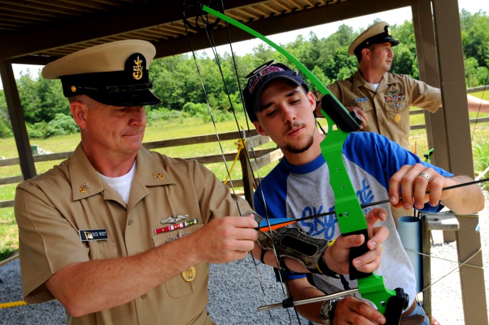 US Navy 090609-N-9818V-142 A staff member from Skymont Boy Scout Camp gives Master Chief Petty Officer of the Navy (MCPON) Rick West a bow and arrow to try his hand at archery during his visit to the camp
