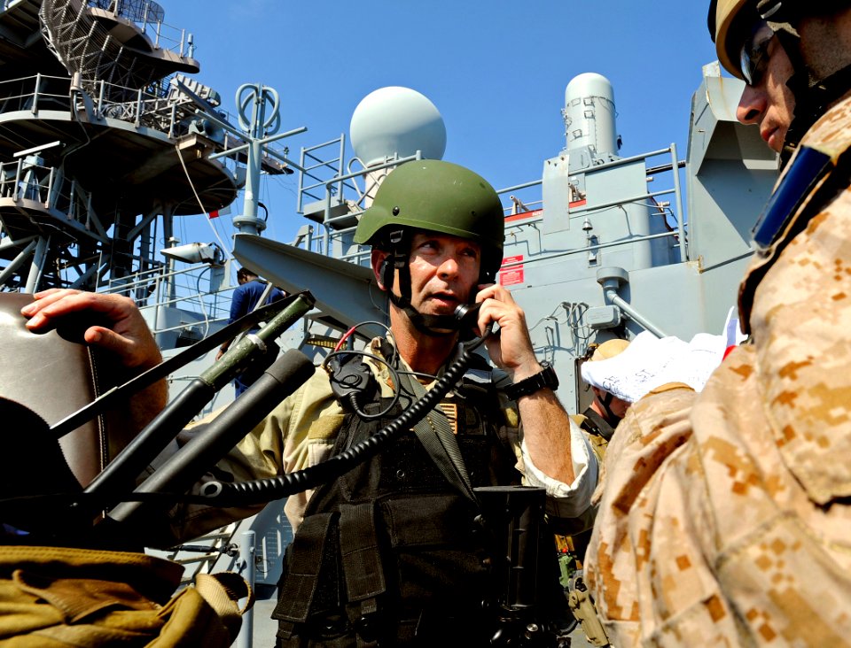 US Navy 090609-N-5345W-191 LT John Fairweather, a Visit, Board, Search and Seizure (VBSS) team leader assigned to Naval Beach Group 2, calls in a status update to leadership aboard USS Bataan (LHD 5)