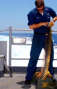 US Navy 090609-N-9132C-428 Aviation Ordnanceman 3rd Class Ryan Ball loads ammunition into a .50 caliber rifle