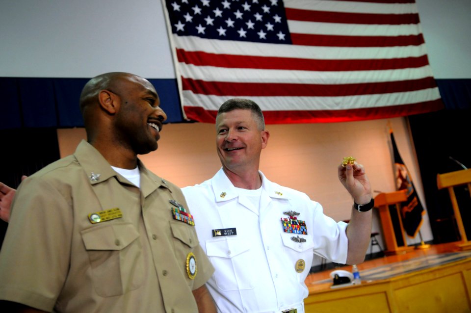 US Navy 090610-N-9818V-104 Master Chief Petty Officer of the Navy (MCPON) Rick West presents Gunner's Mate 1st Class James Glenn with a MCPON challenge coin