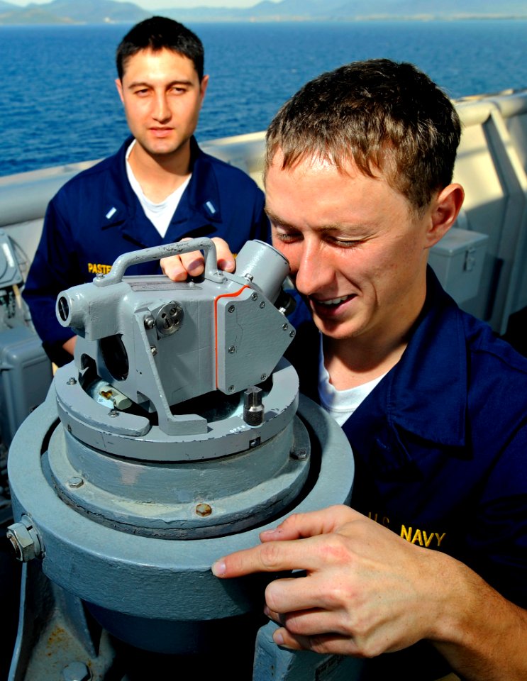 US Navy 090605-N-5345W-134 Midshipmen 2nd Class Alex Guffey, an NROTC student at Auburn University, receives instructions from Lt. j.g. Jonathan Pastell on how to take a bearing reading