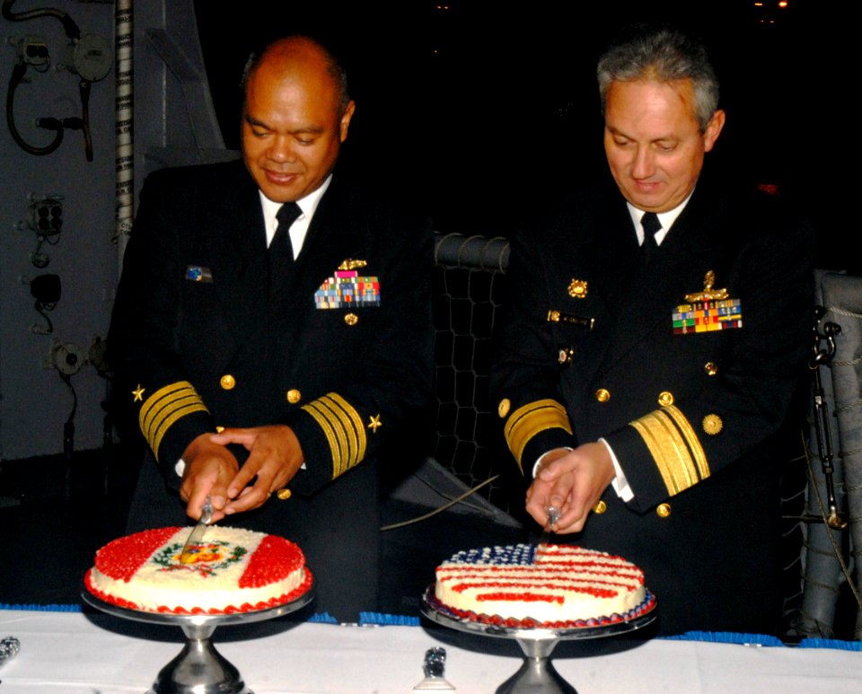 US Navy 090611-N-4879G-197 Commander of Destroyer Squadron (DESRON) 40 Capt. Rodelio Laco and Vicealmirante Carlos Chanduvi Salazar cut cakes during a reception aboard the guided missile frigate USS Doyle (FFG 39)