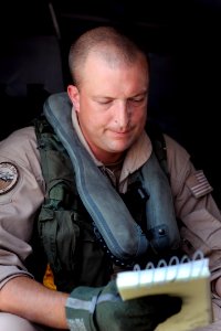 US Navy 090610-N-0413R-059 Naval Air Crewman 1st Class Jeff Richardson goes over the pre-flight checklist, ensuring all mission systems are satisfactory before take off at Naval Air Station Jacksonville, Fla